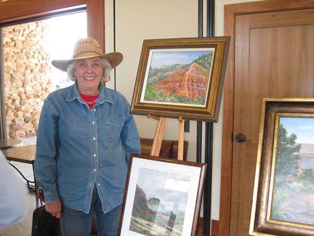 Janette standing next to her artwork on an easel